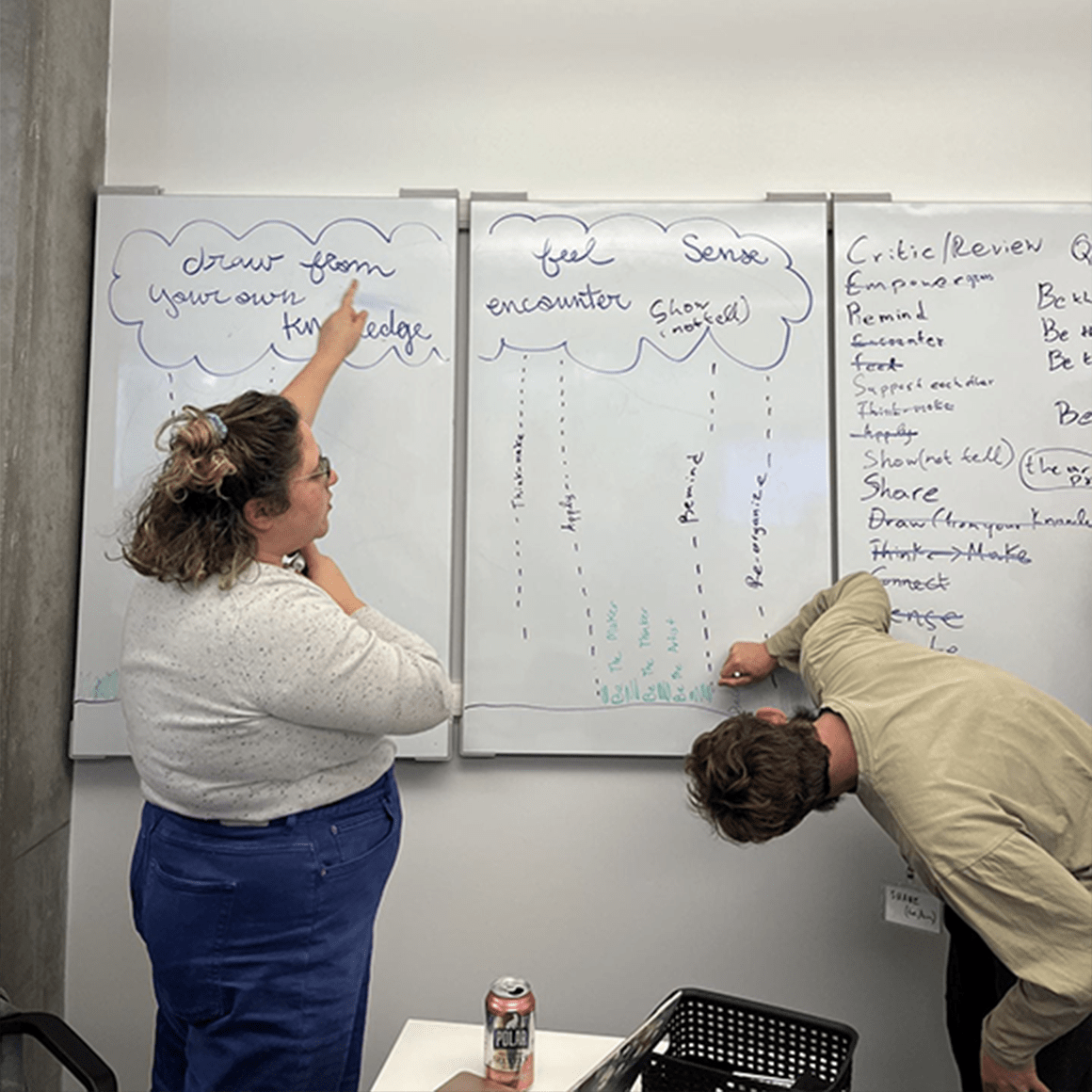 Two graduate students working at a whiteboard.