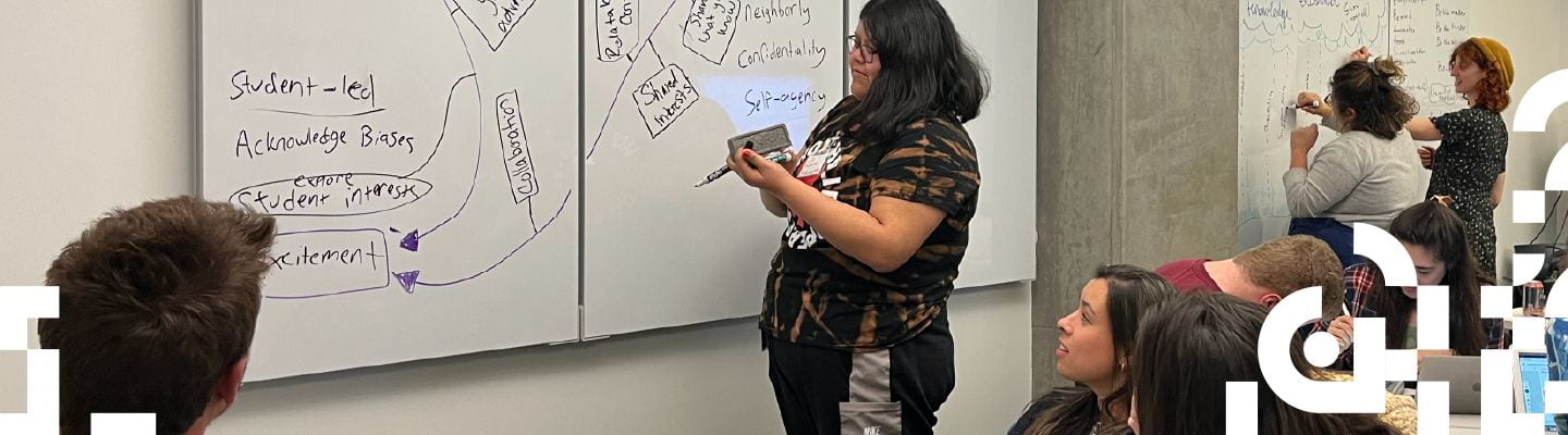 Grad students working at white boards. Writing on the board: "Confidentiality," "Shared Interest," "Self-agency," and "Student led"
